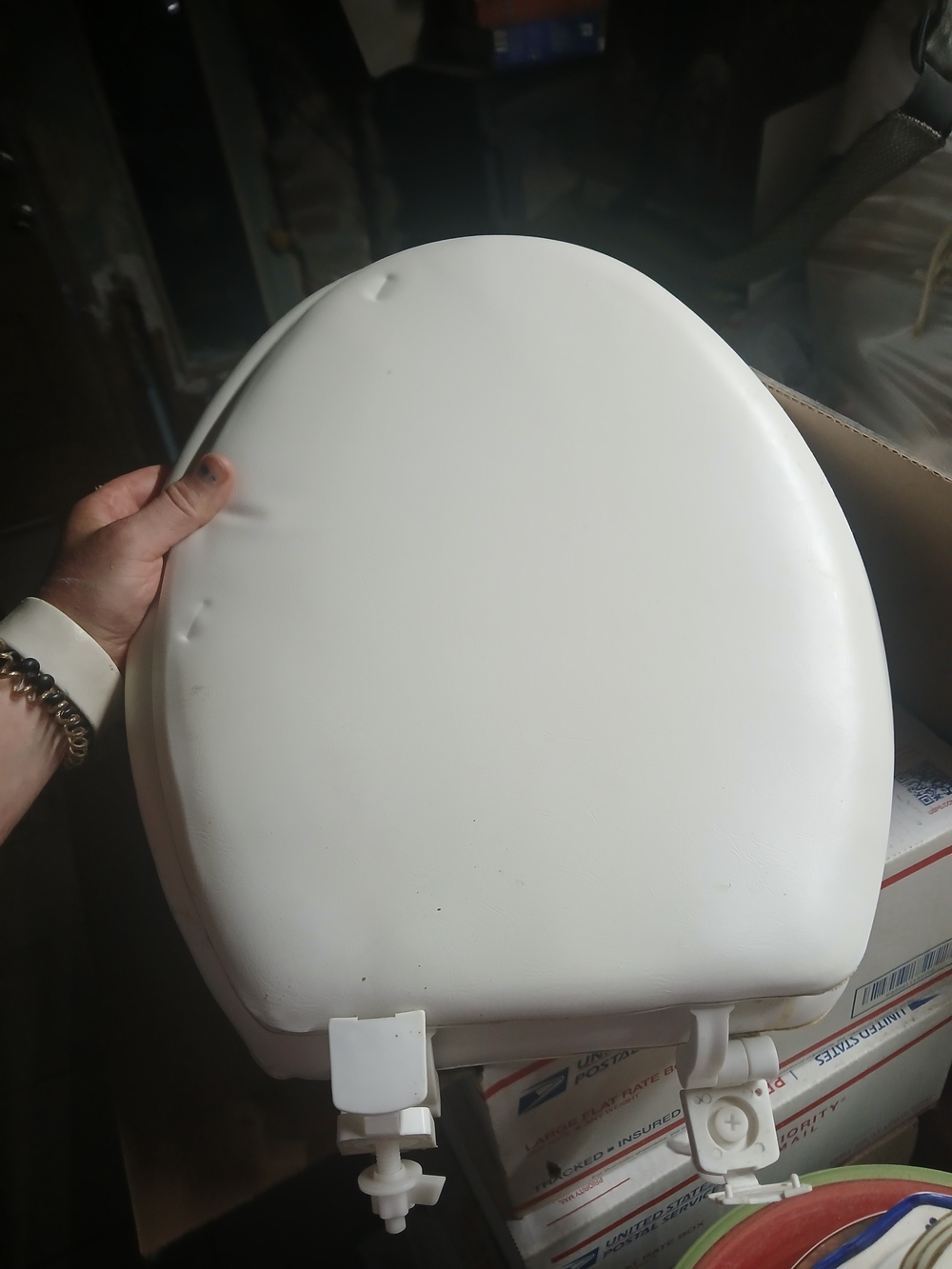 white toilet seat with mounting hinges attached at the top 17"x14"x2"
